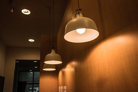 ceiling-lighting-fixture-lamps-hanging-along-the-curved-of-wooden-wall-in-modern-cafe.jpg